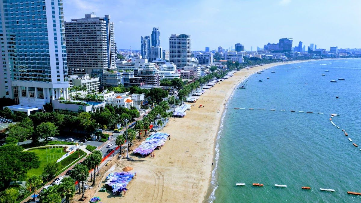 Pattaya skyline and Gulf of Thailand at sunset — the view Altitude Rooftop Bar's west-facing 14th-floor terrace at Amari Pattaya looks out over