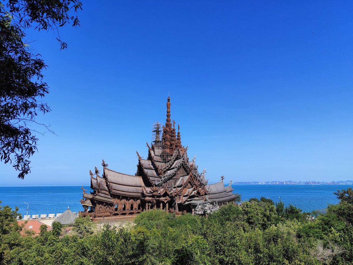 The Sanctuary of Truth wooden temple rising above the trees with the blue Gulf of Thailand behind it